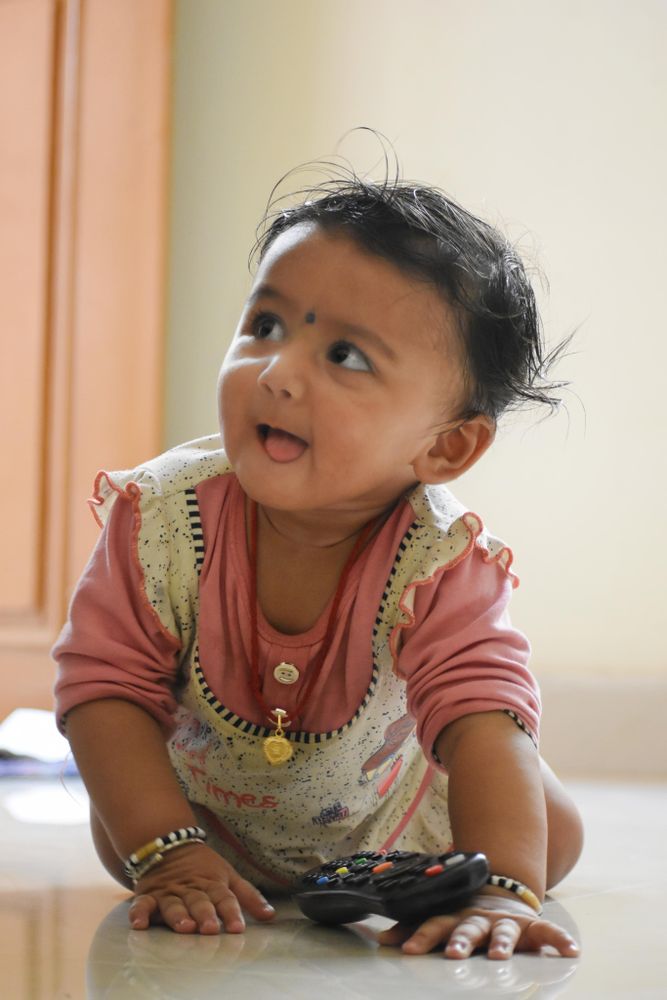 Young Indian girl crawling on the floor