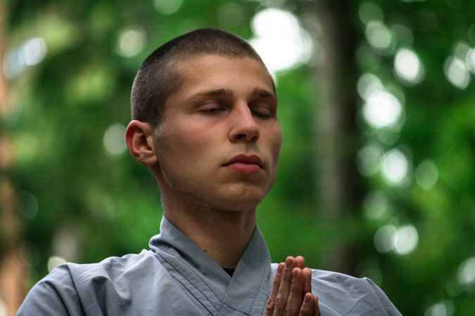 Young man meditating in garden