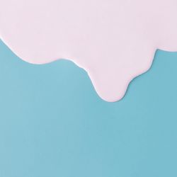 Abstract pink oil paint dripping texture on blue canvas