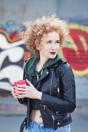 Curly haired woman in leather jacket outdoors