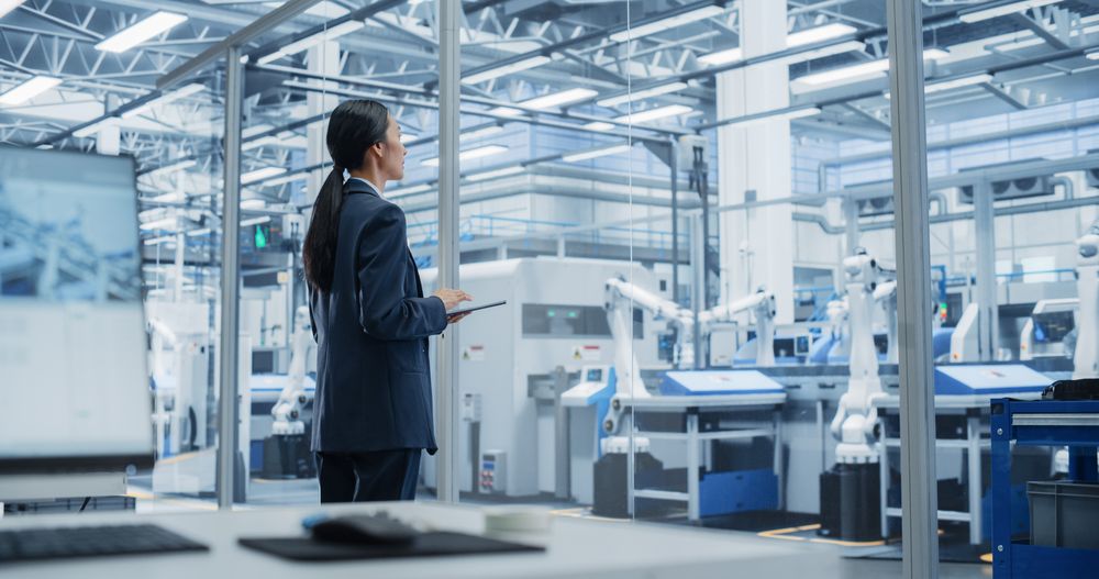 Electronics Manufacturing Technician Working on Tablet Computer at a Factory Space. Asian Female Specialist Developing, Maintaining, and Fine-Tuning Programs for Machine Production and Assembly