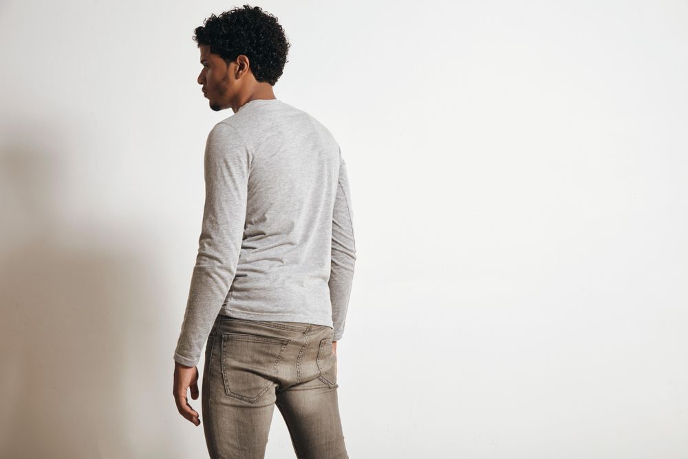 Rear view of man dressed in grey in studio