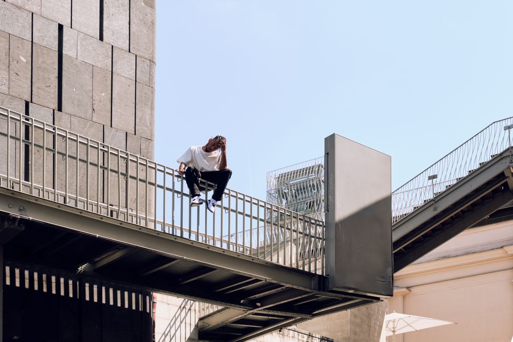 Black male sitting on bridge