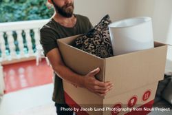 Man walking with a cardboard packing box at home 481PXb