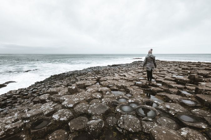 Female standing on cliff and contemplating