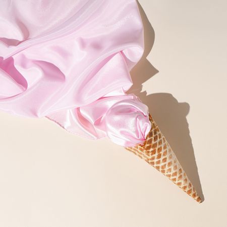 Vintage style concept with ice cream cone and pink fabric.