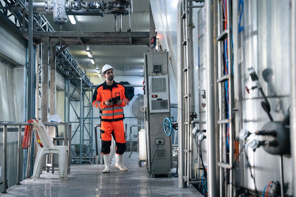 Engineer worker checking machine of conveyor belt system at the canned food factory.