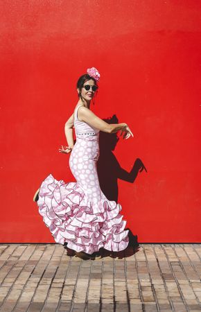 Passionate woman in flamenco dress dancing on street