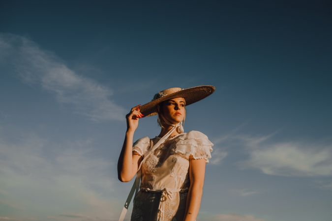stately woman in hats in bright sunny day