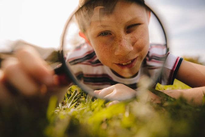 Cute boy exploring with magnifying glass