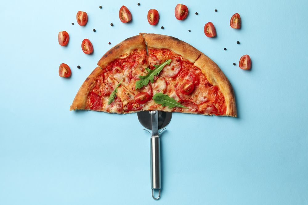 Umbrella made of pizza on blue background