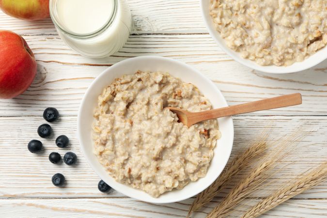 Composition with oatmeal porridge on plain wooden background. Cooking breakfast