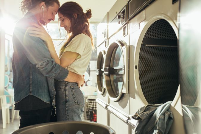 Cute young couple waiting for laundry in a laundromat