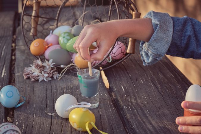 Easter eggs painted by kid on wooden table