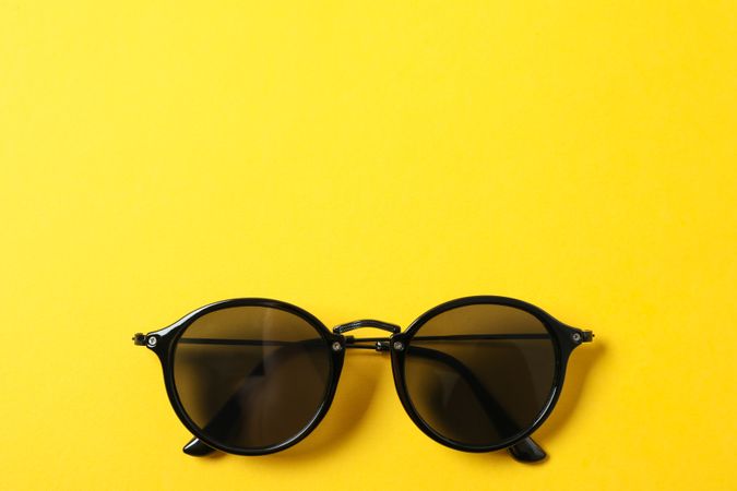Sunglasses on color background, space for text and closeup. Fashionable accessories