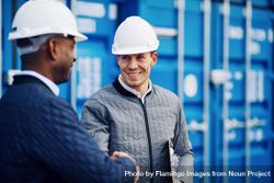 Two men in hard hats smiling and shaking hands 5rGx14