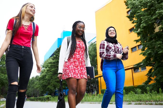 Smiling multi-ethnic group of female friends walking between class