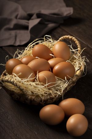 Basket with brown chicken eggs goes up the table.