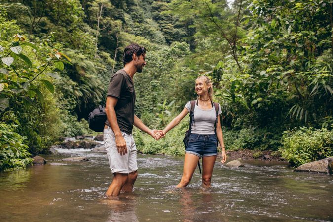 Loving young couple standing in forest stream