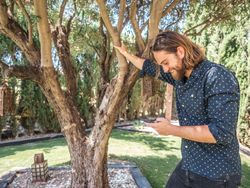 Trendy handsome male with phone on terrace
