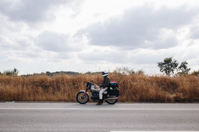 Man with motorcycle on hard shoulder