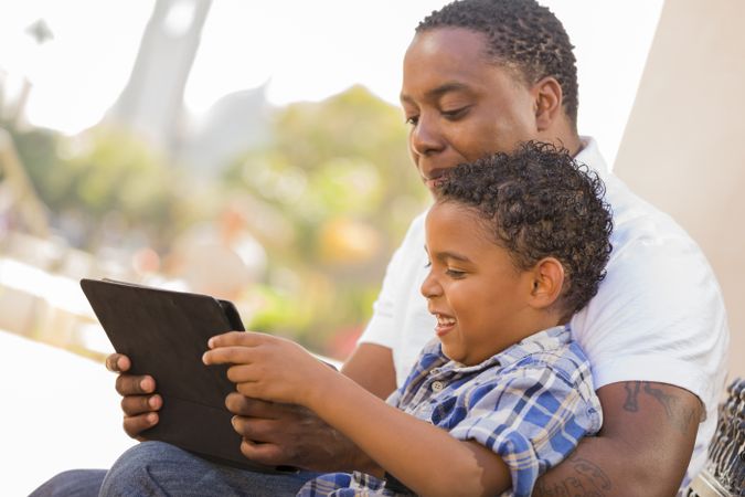 Father and Son Using Tablet Outside