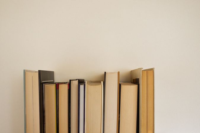Multiple books put against light wall