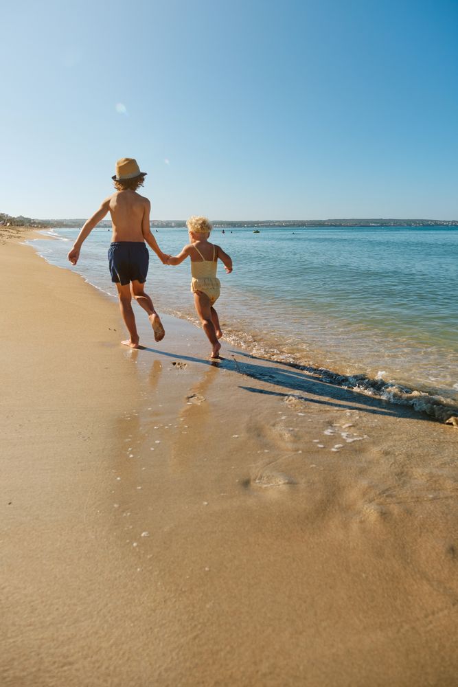 Children running and holding hands at seaside