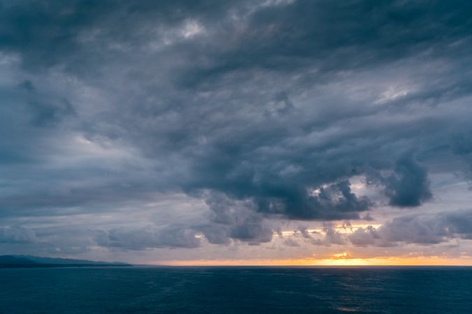 Gray clouds on sundown sky over sea