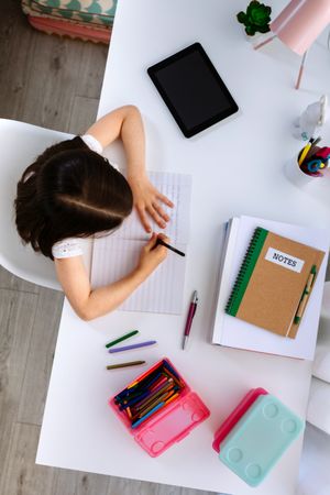 Girl doing homework sitting at a desk