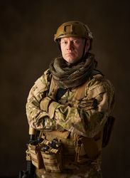 portrait of an airsoft soldier in camouflage clothing with arms crossed
