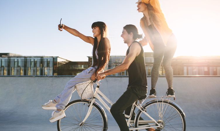 Group of friends having fun bike riding together at skate park