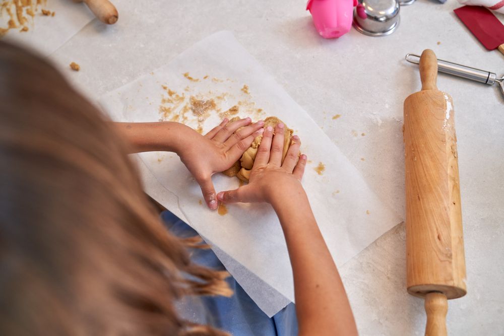 Unrecognizable kid kneading cookie dough