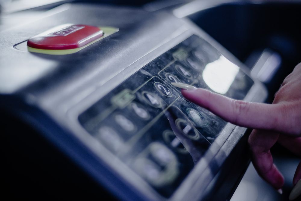 Woman pressing the 2 button on the treadmill panel, detail shot