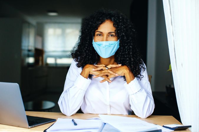 Confident woman wearing a facemask working on documents