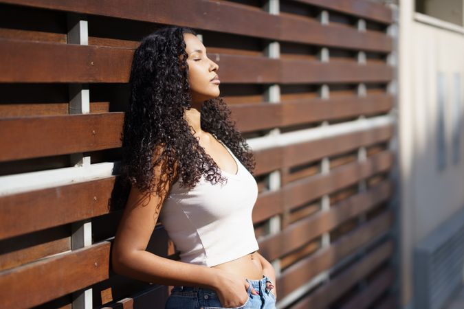 A portrait capturing the essence of a young woman with curly hair against a wooden background