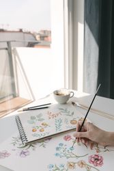 Person drawing flowers with watercolor