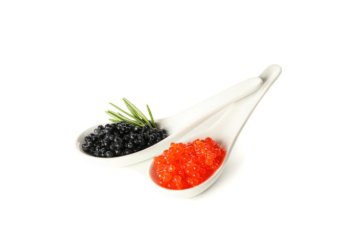 Glass spoons with caviar isolated on blank background