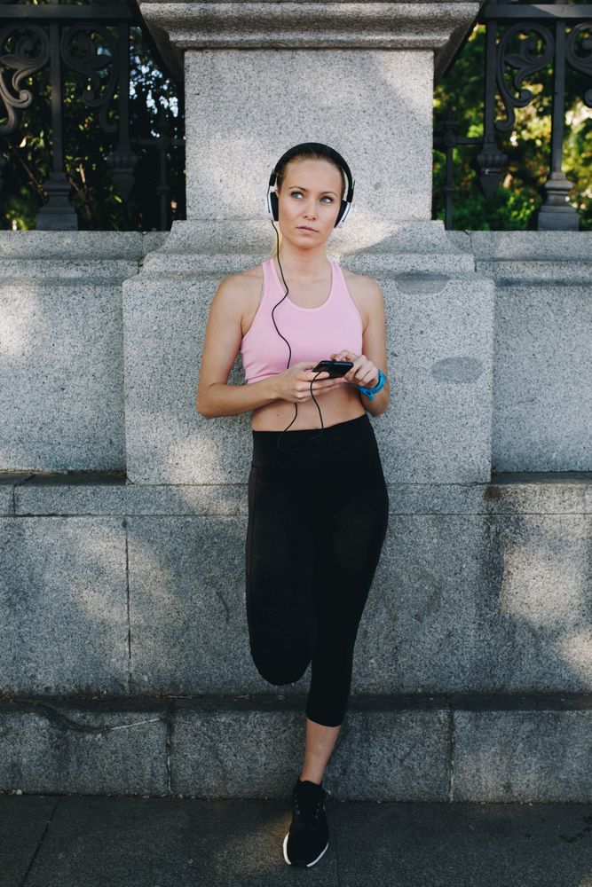 Woman with sportswear listening to music with headphones