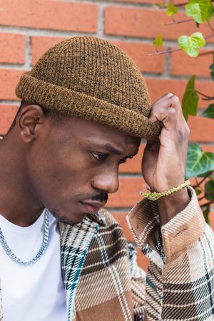 Stylish Black man against brick wall