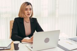 Woman speaking from behind her laptop