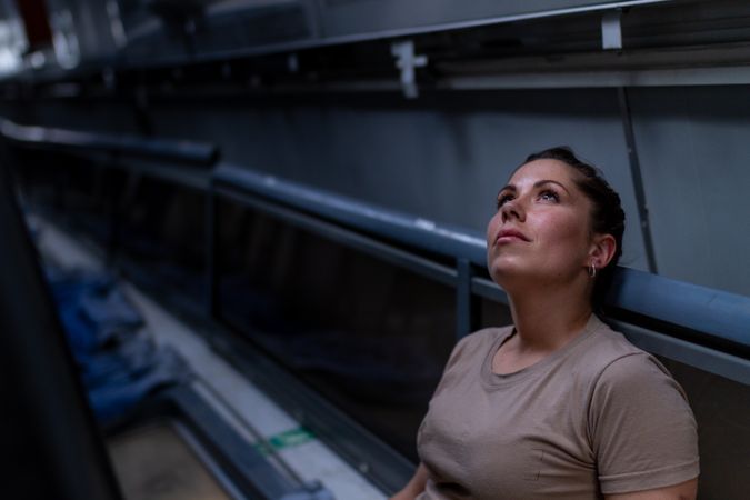 Military woman looking up inside vehicle