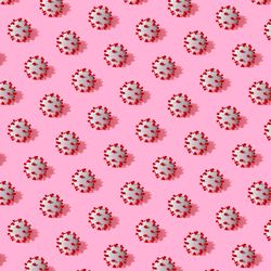 COVID-19 virus pattern in rows on pink background