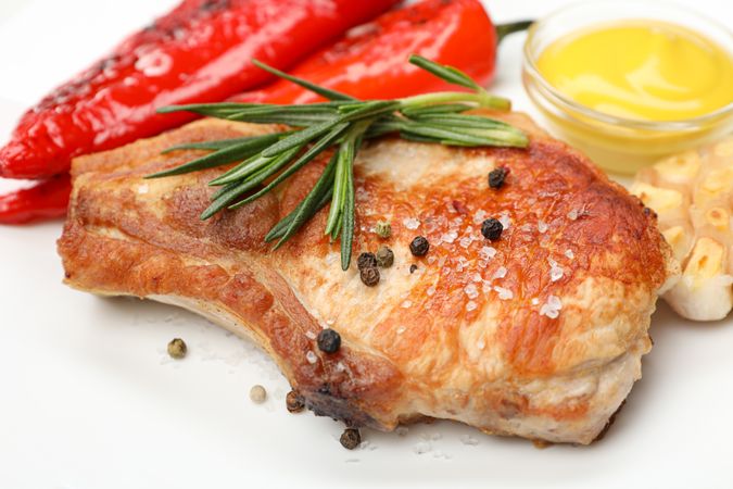 Fried steak, garlic and pepper, and sauce on blank background, close up