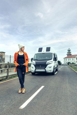 Female walking in front of parked van, vertical