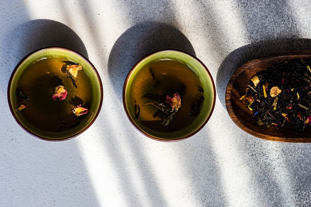 Two cups of green tea and tea leaves