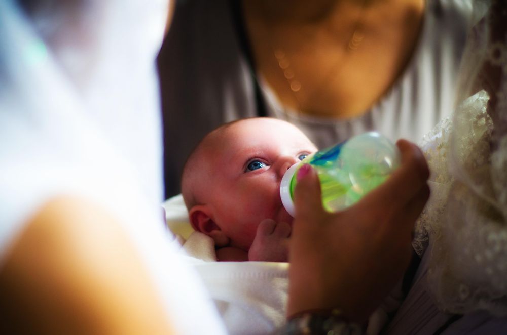 Baby being bottle fed by an adult
