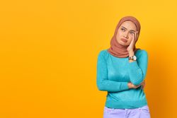 Sad Muslim woman with hand on her face
