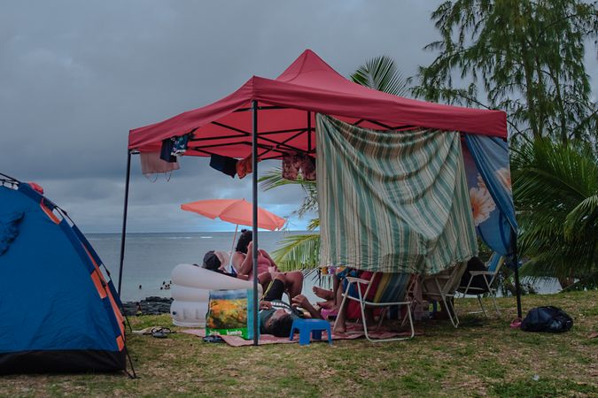 Beach tent set up on grass near the water