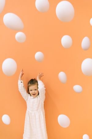 Happy girl throwing eggs in room